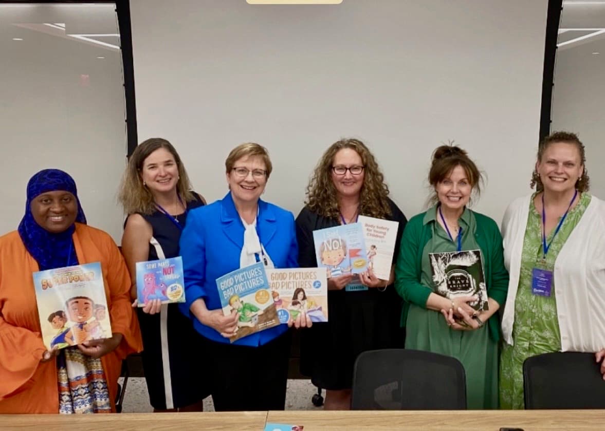 Kimberly King on a panel with five other authors and educators holding children's safety books